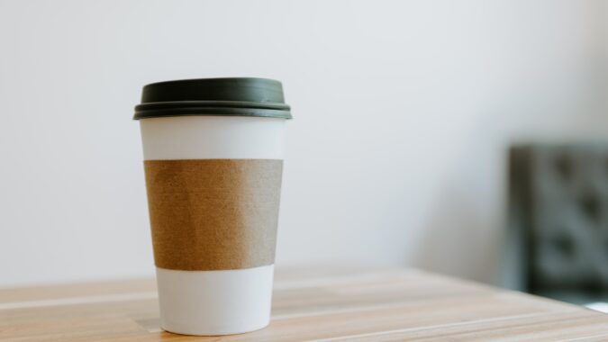 single-use plastic cup and lid on a table