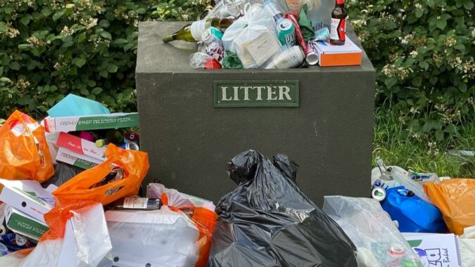 litter bin surrounded by rubbish.