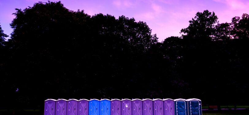 portaloos lined up in a field.