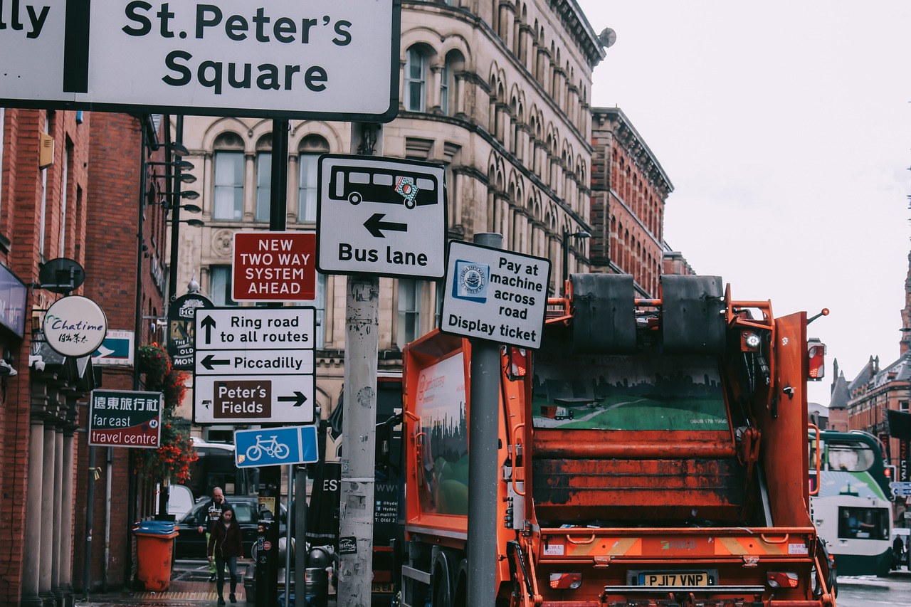 waste truck driving in central Manchester.