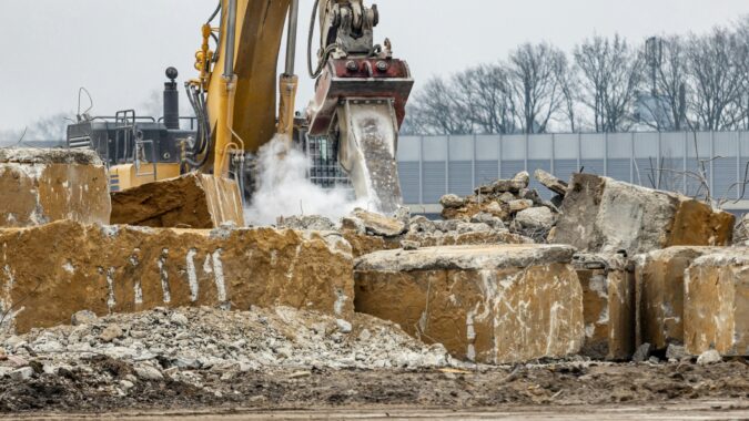 bulldozer drilling through rubble at a building site.