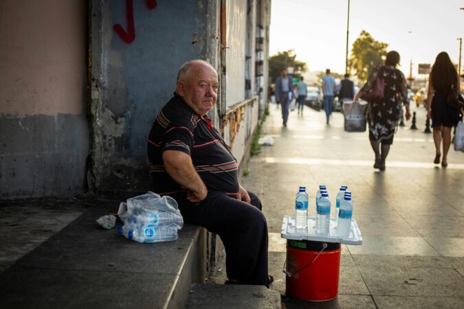 man selling plastic water bottles on the street.