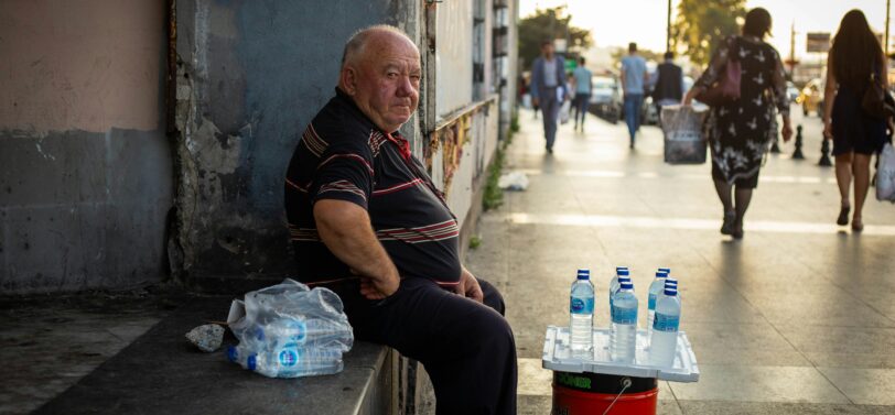 man selling plastic water bottles on the street.